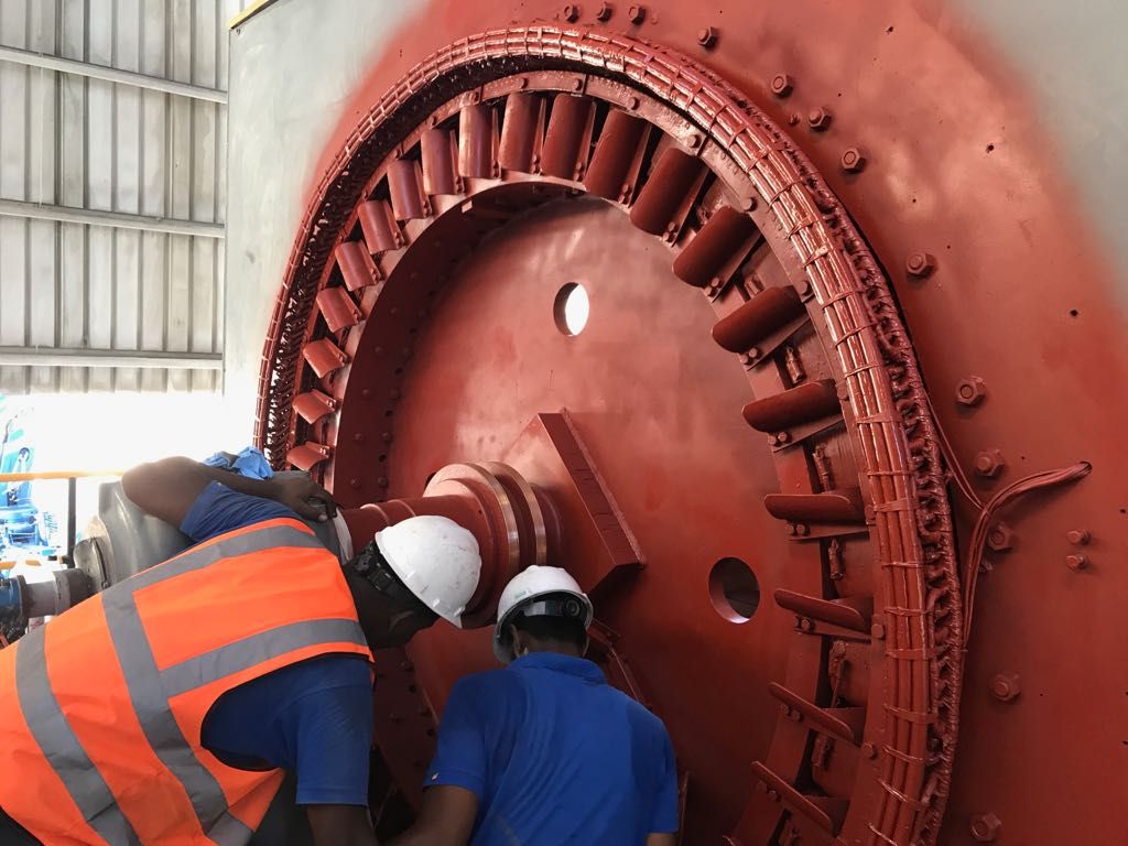Técnicos trabajando dentro de una máquina de gran porte